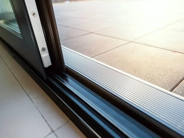 Specialist fitting a new sliding patio door lock mechanism into a uPVC door panel